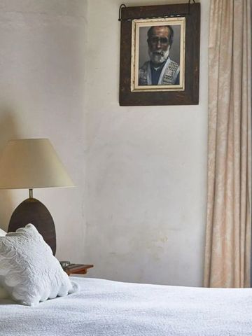 Heller Raum mit Doppelbett weißer Bettwäsche und dekorativem Gemälde.