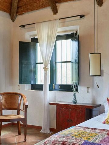 Schlafzimmer mit rustikalem Dekor und farbenfrohem Bettüberwurf in der Hacienda.