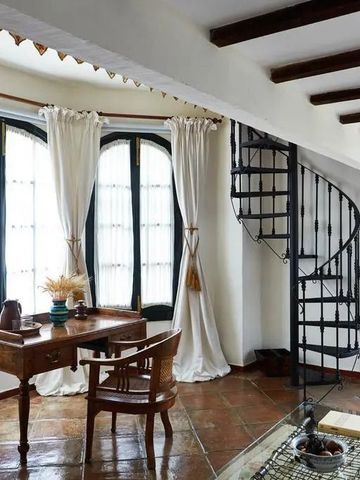Helles Wohnzimmer mit Wendeltreppe und elegantem Schreibtisch