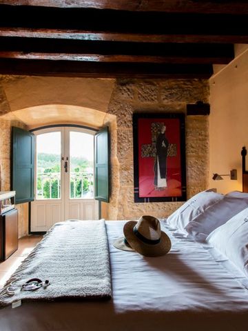 Helles Hotelzimmer mit Doppelbett und geöffneten Fenstern mit Blick nach draußen