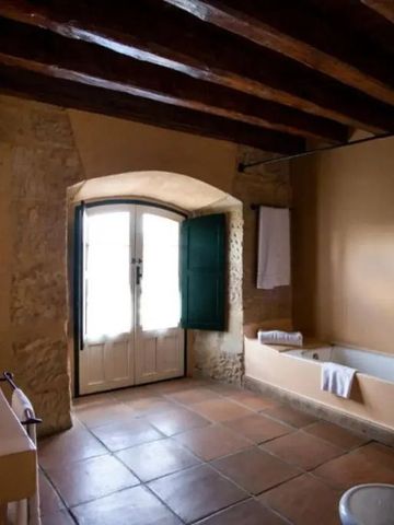 Großes Badezimmer mit Badewanne und natursteinverkleideten Wänden