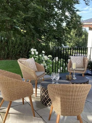 Gemütliche Sitzgruppe im Freien mit Holztisch und Aussicht auf Garten