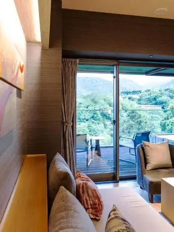 Luxuriöses Zimmer mit Zugang zu einem Balkon mit Waldblick
