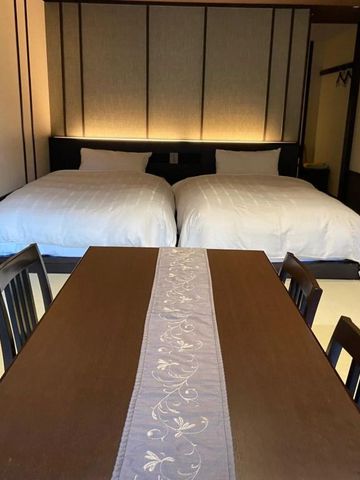 Japanisches Zimmer mit zwei Betten und einem Esstisch.