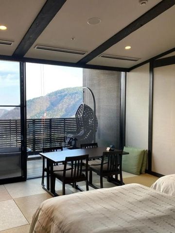 Helles Zimmer mit Panoramafenster und Sitzbereich.