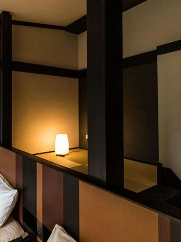 Japanisch inspiriertes Hotelzimmer mit schlichter Beleuchtung und Holzelementen