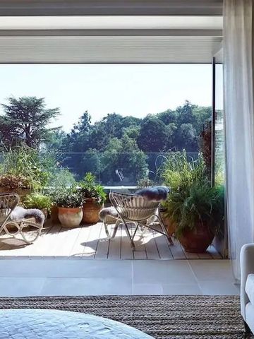 Helle Hotelterrasse mit üppiger Bepflanzung und Ausblick ins Grüne