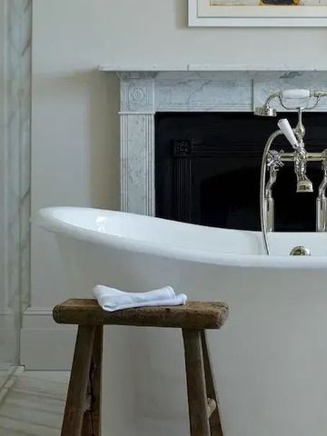 Edles Badezimmer mit freistehender Badewanne und Marmorkamin