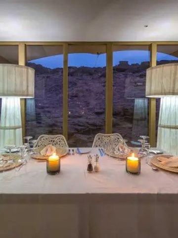 Gemütlicher Dinner-Tisch mit Kerzen und Blick auf Felsen im Hoanib Skeleton Coast Camp