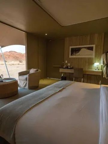 Geräumiges Schlafzimmer mit Blick auf die Wüstenlandschaft im Hoanib Skeleton Coast Camp