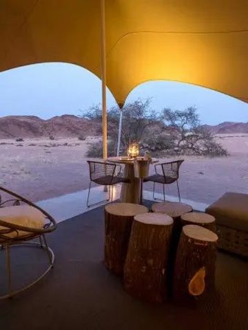 Private Terrasse mit Sitzgelegenheiten und Blick auf die Wüste bei Sonnenuntergang