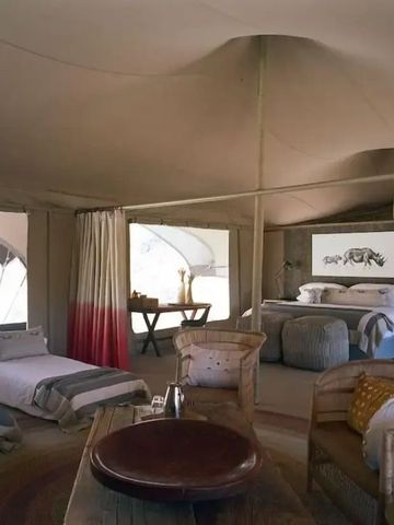 Helles Interieur einer luxuriösen Zelt-Suite mit Bett und gemütlichen Sitzgelegenheiten