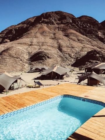 Infinity-Pool mit Blick auf imposante Felsformationen im Hoanib Valley Camp