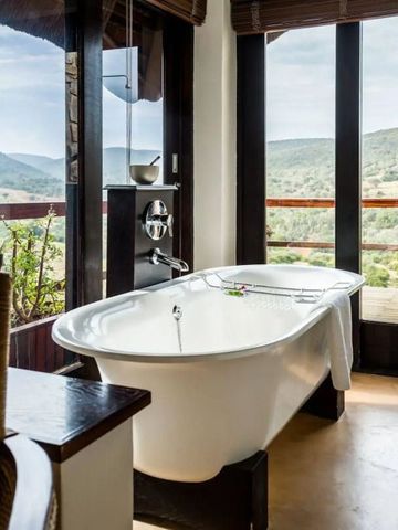 Freistehende Badewanne mit Panoramablick auf hügelige Landschaft