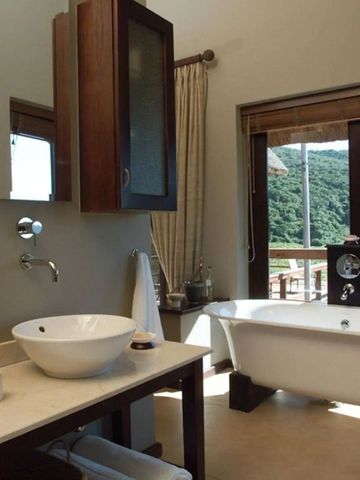 Badezimmer mit Blick auf grüne Landschaft und freistehender Badewanne