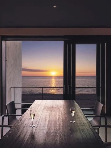Speisesaal mit Meerblick bei Sonnenuntergang und zwei Champagnergläsern