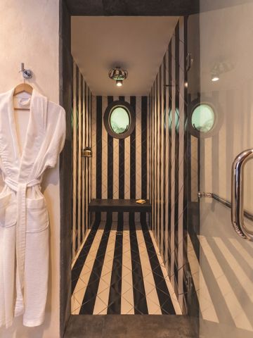 Elegante Duschkabine in Schwarz-Weiß mit luxuriösem Bademantel