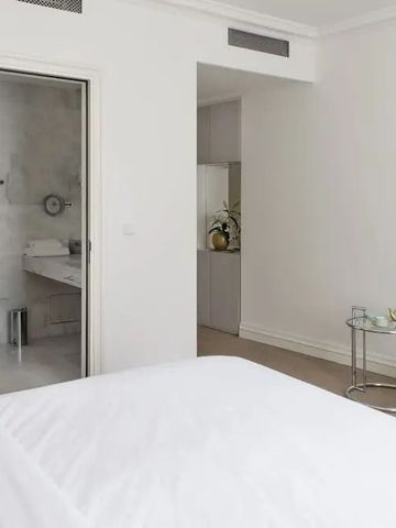 Helles Hotelzimmer mit eleganter Einrichtung und direktem Badzugang.