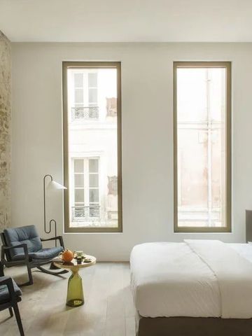 Hotelzimmer mit Steinwand, modernen Möbeln und natürlichem Licht.