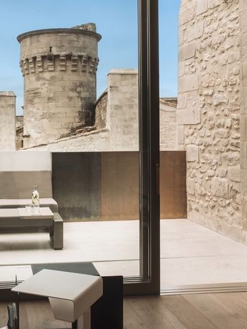 Moderne Terrasse mit Blick auf historischen Turm und Steinmauern