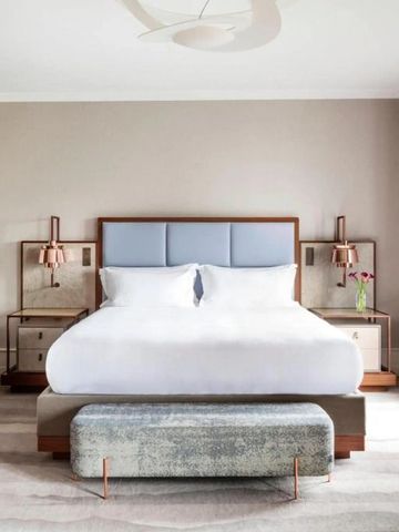Elegantes Hotelzimmer mit modernem Design und großen Fenstern sowie weißer Bettwäsche