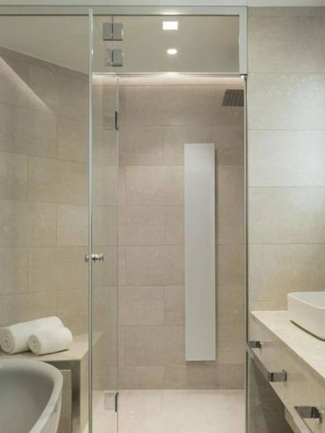 Modernes Badezimmer mit Dusche, edlem Waschbecken und hochwertigen Materialien