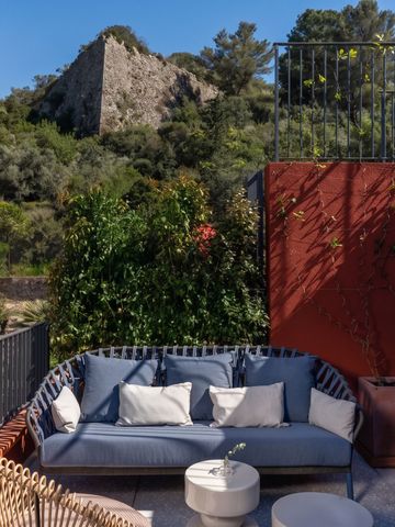 Gemütliche Terrasse mit Sofa und Blick auf Natur und Ruine