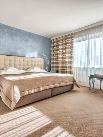 Helles Zimmer mit großem Doppelbett und modernen Möbeln