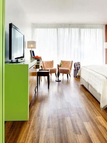 Zeitgemäßes Zimmer mit Holzboden und heller Einrichtung