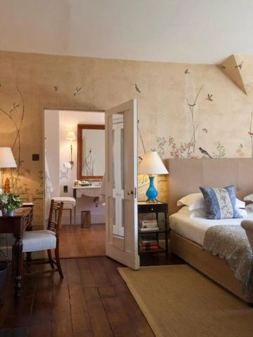 Luxuriöses Schlafzimmer mit Wandmalerei und edlen Holzböden