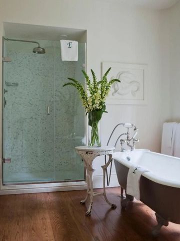 Elegantes Badezimmer mit freistehender Badewanne und Glasdusche im Hotel Endsleigh.