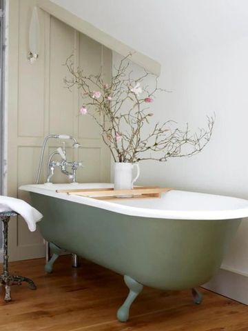 Charmantes Badezimmer mit freistehender Badewanne und dekorativen Zweigen im Hotel Endsleigh.