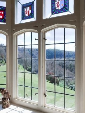 Großes Fenster mit Blick auf die Landschaft und dekorative Glasfenster im Hotel Endsleigh.