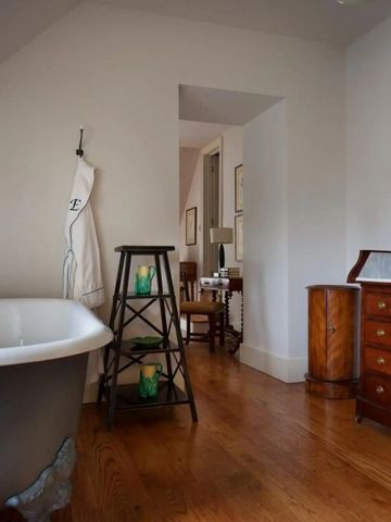 Luxuriöses Badezimmer mit antiker Kommode und freistehender Badewanne im Hotel Endsleigh.