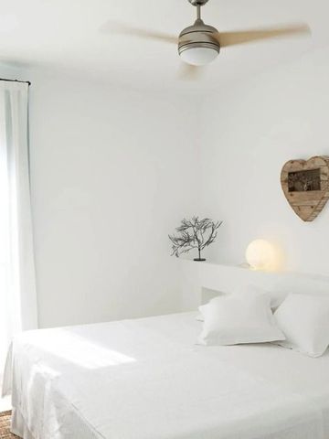 Helles Hotelzimmer mit weißen Möbeln und herzförmigen Dekorationen an der Wand
