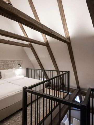 Gemütliches Dachzimmer mit Balken und zwei Betten