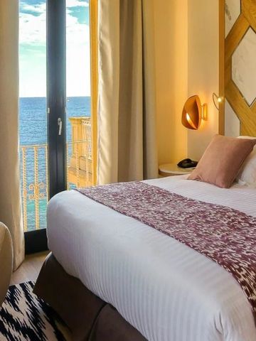 Blick aus einem Hotelzimmer auf den Ozean durch ein Fenster