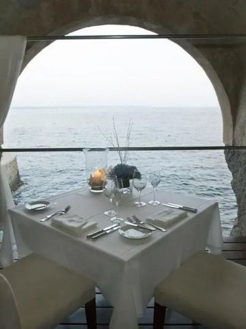 Romantischer Tisch mit Meerblick durch einen Rundbogen