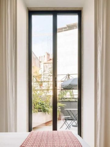 Blick aus dem Hotelzimmer auf eine Terrasse mit Sitzbereich
