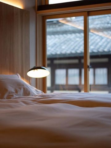 Gemütliches Schlafzimmer mit Blick auf traditionelle Architektur durch große Fenster