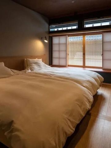 Modernes Doppelbettzimmer mit japanischen Schiebetüren und Holzboden