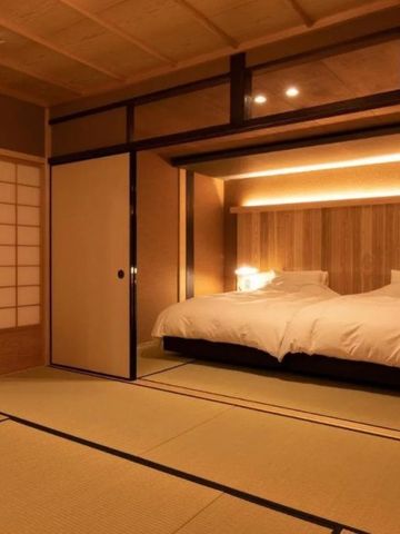 Tatami-Zimmer mit großem Bett und moderner Beleuchtung im traditionellen Stil