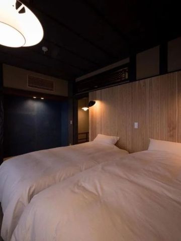 Doppelzimmer mit zwei Betten und stilvoller Holzvertäfelung