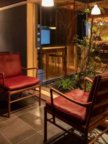 Lounge-Bereich mit roten Sesseln und großen Fenstern