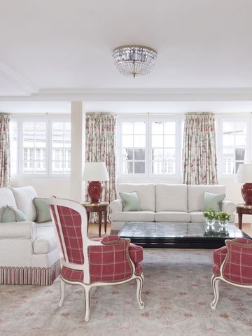 Helle Lounge mit weißen Sofas und roten Sesseln