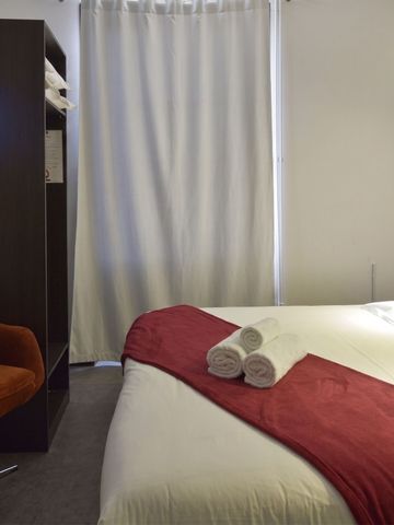 Elegantes Hotelzimmer mit Bett und roten Akzenten