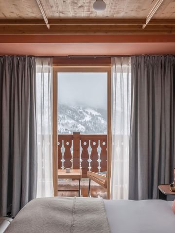 Gemütliches Schlafzimmer mit Ausblick auf verschneite Berge im Hotel Le Coucou