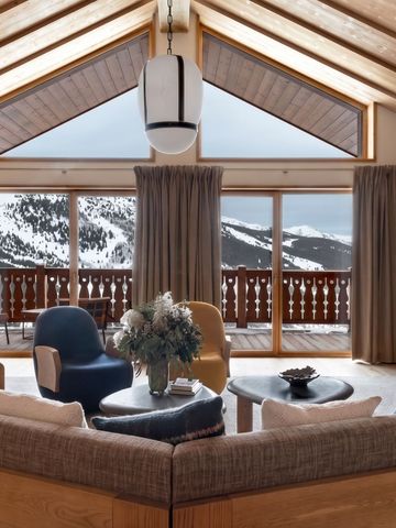 Luxuriöser Wohnbereich mit Panoramafenstern und Blick auf verschneite Berge