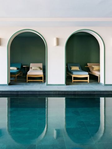 Innenpool mit eleganten Liegen und Bögen