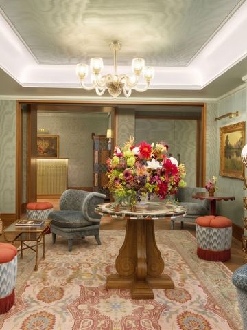 Prächtig eingerichtete Lounge mit Blumen und eleganten Sitzmöbeln